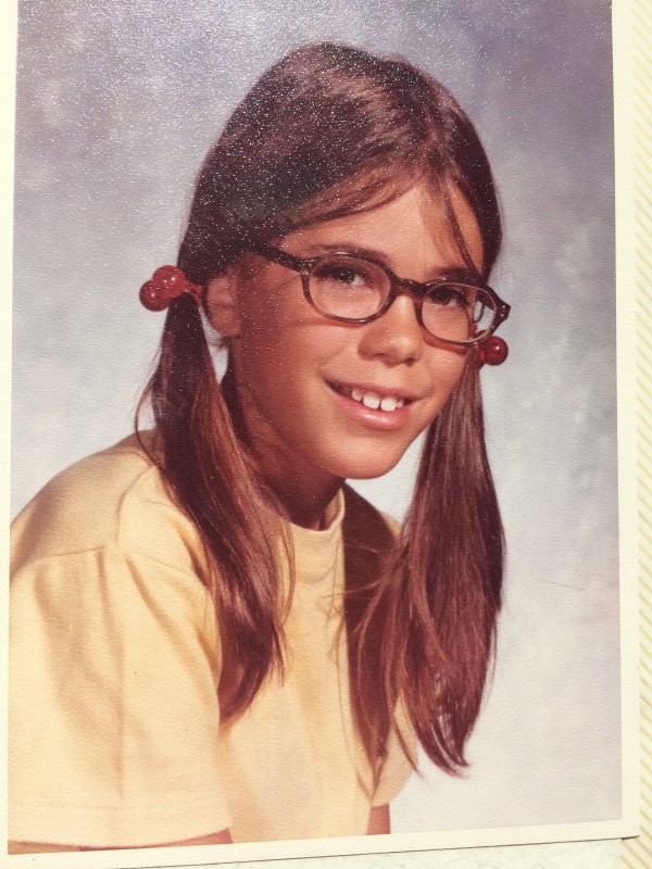 10 year old girl with glasses and pigtails and a yellow shirt