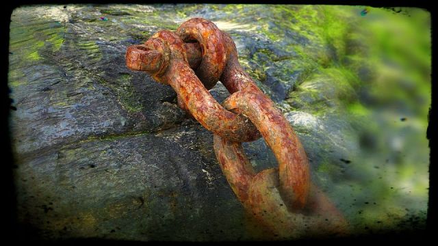 rusty chain bolted to a rock