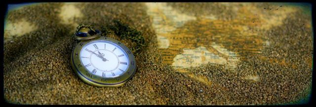 pocket watch on map with sand